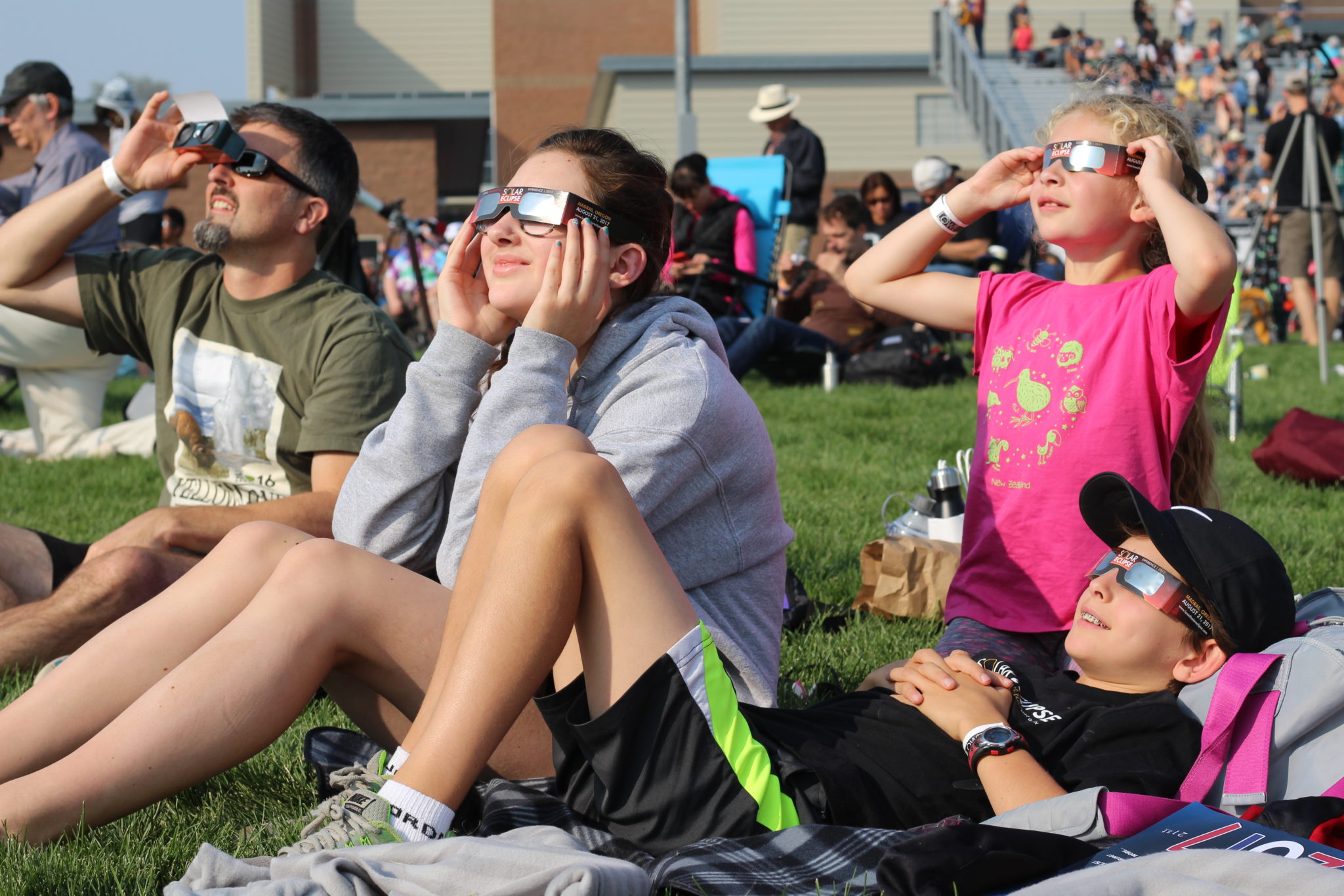 A family safely views the partially eclipsed Sun during Lowell