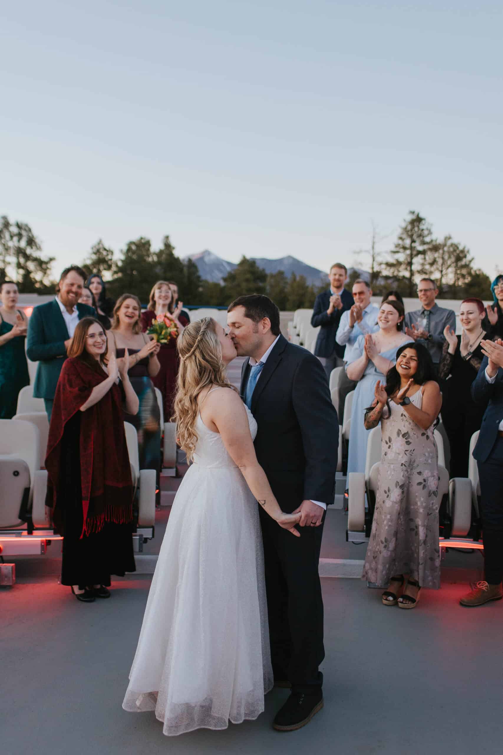 Couple getting married at Lowell Observatory outdoor wedding ceremony with guests clapping.