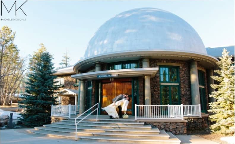 Exterior view of Lowell Observatory venue rental building with a dome and surrounding trees.
